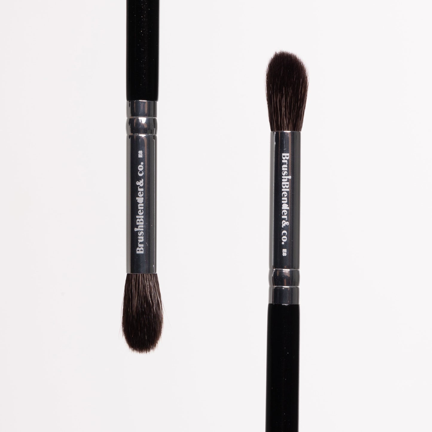 Two makeup brushes with black handles and brown bristles on a white background